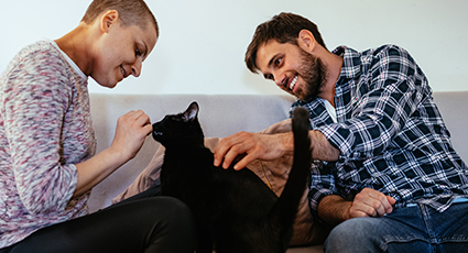 Man and woman with cat on sofa