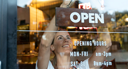 Women in café hanging up open sign