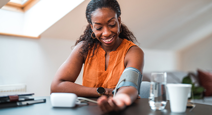 Woman smiling and checking her blood pressure