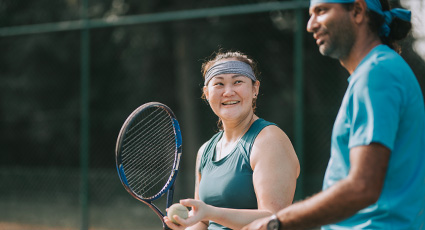 MIddle-aged man and womain on the same side, playing tennis